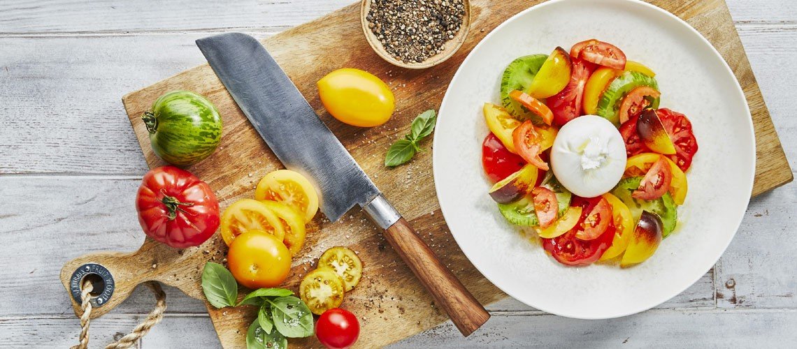 Scharfes Santokumesser und geschnittene Tomaten