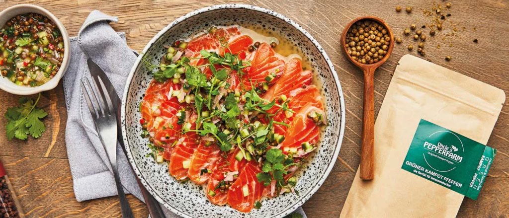 Lachs-Ceviche mit einem Sud aus grünem Kampot Pfeffer serviert