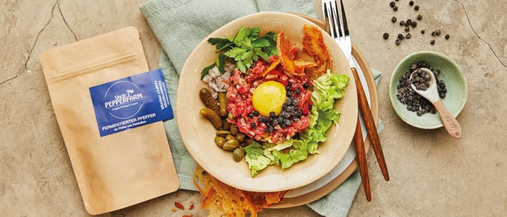 Beef Tatar mit fermentierten Kampot Pfeffer auf Teller serviert